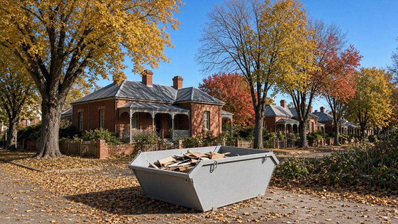Grey skip bin in a heritage street in Armidale with autumn trees